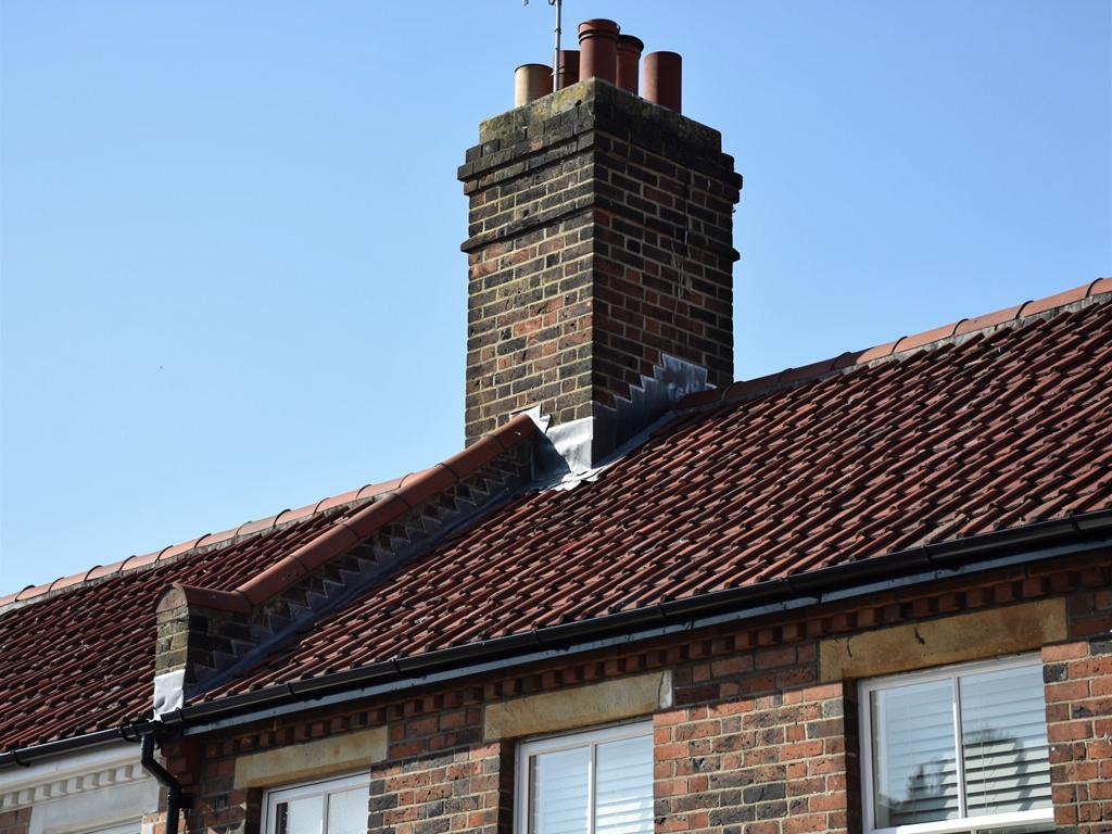 Victorian terraced house roof with chimney and clay tiles